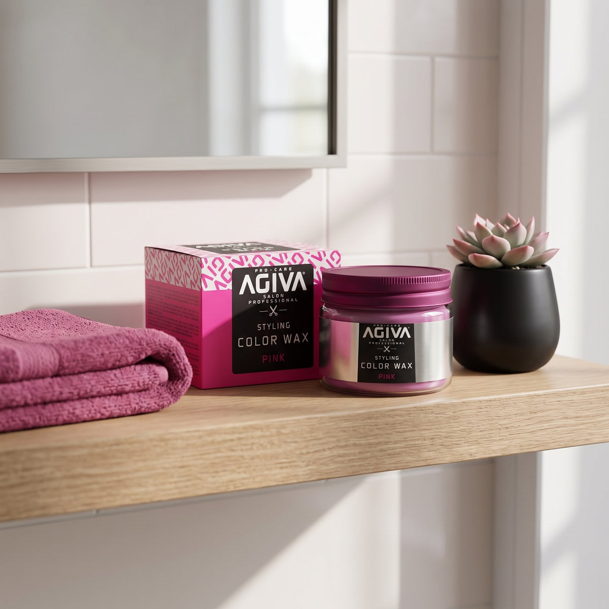 AGIVA Color Wax Pink glas og æske på træhylde med lyserødt håndklæde og lille sukkulent i sort potte.