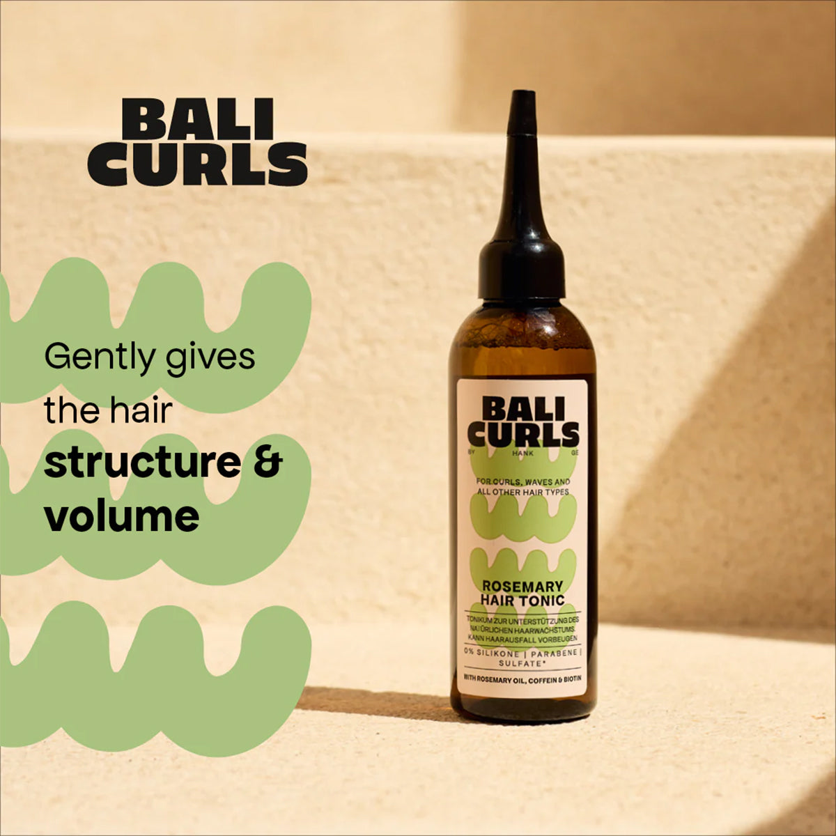 Flaske med BALI CURLS Rosemary Hair Tonic placeret på lys trappe, fremhæver struktur og volumen til krøllet hår.
