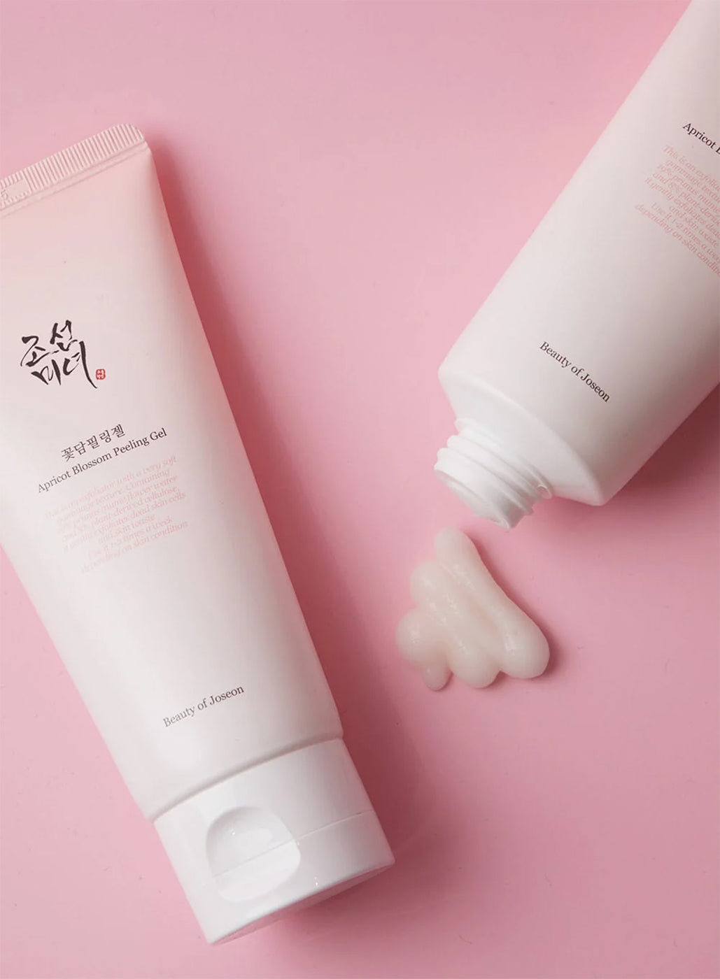 Tube med Beauty of Joseon Apricot Blossom Peeling Gel 100ml og gel på lyserød baggrund.