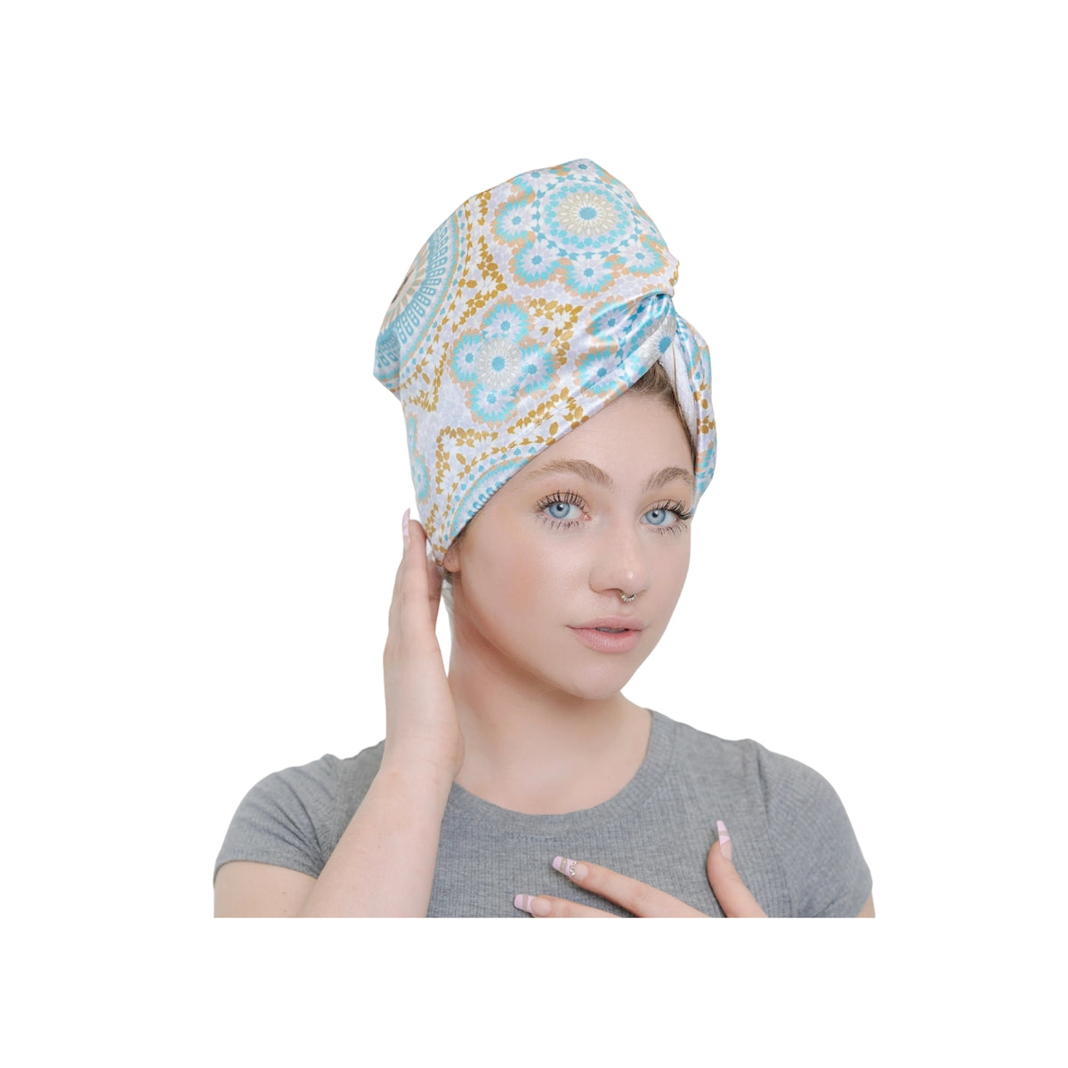 Kvinde iført Bounce Curl Satin Microfiber Turban med farverigt blomstermønster i blå, hvid og gylden farve.